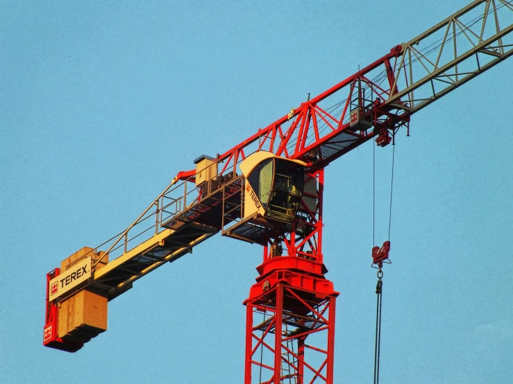 a red and white crane has blue sky in the background