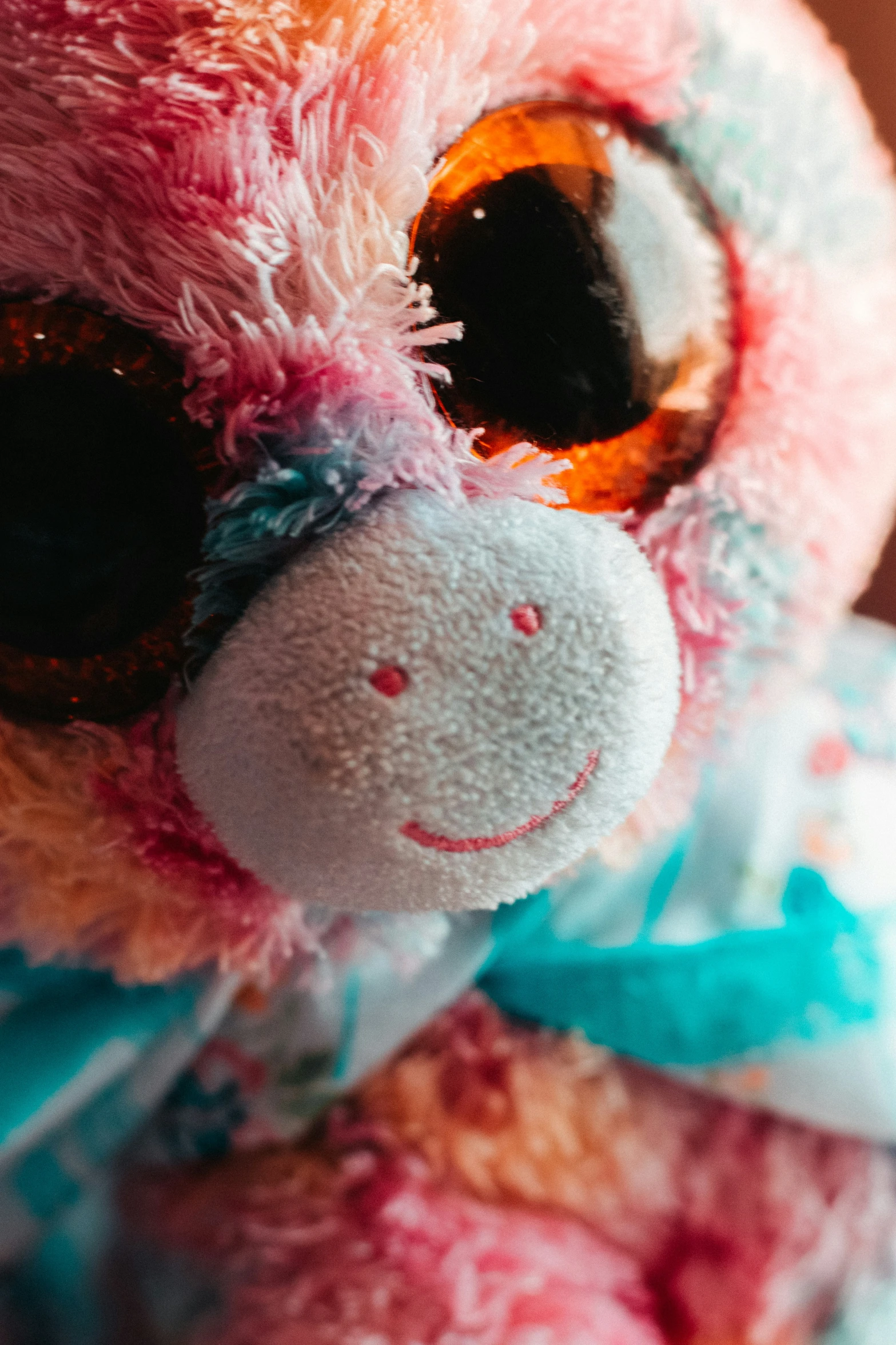 the pink and blue teddy bear has eyes wide open