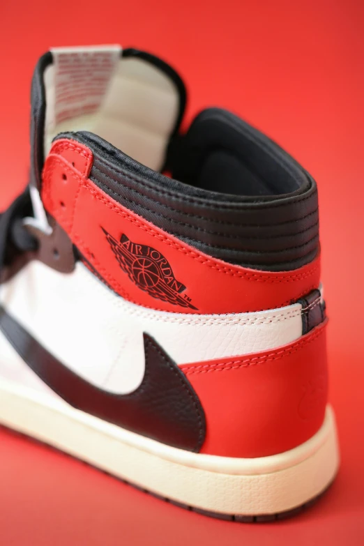 a pair of sneakers is on a red surface