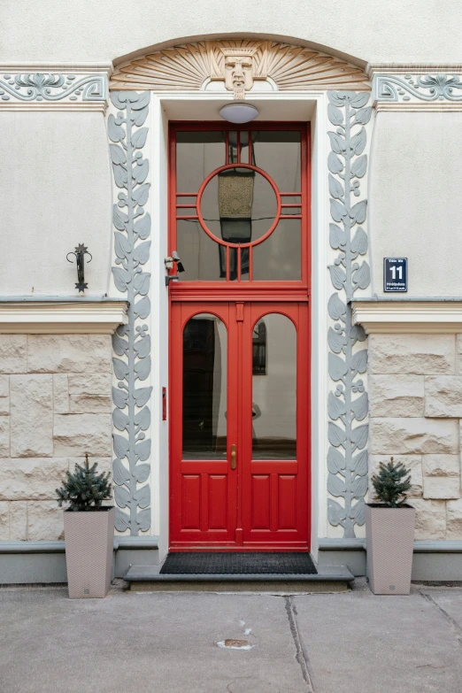 an orange door to a gray building with large windows