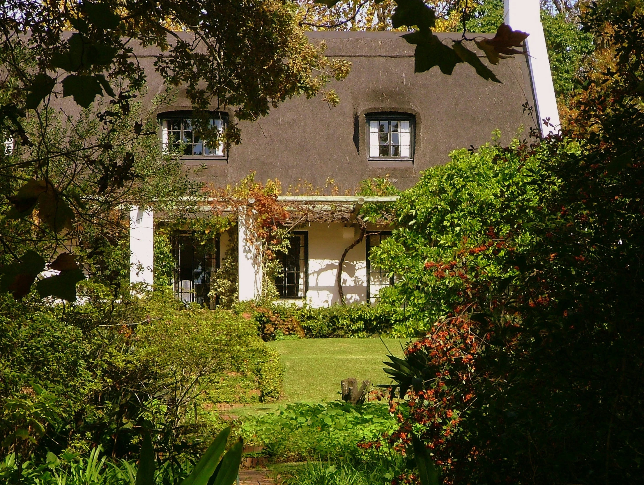 a large house with trees and bushes around it