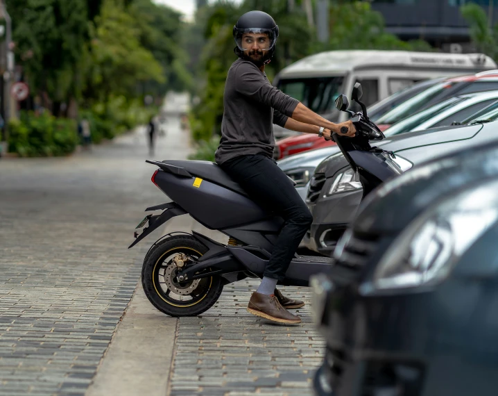 a man in black is standing next to a motorcycle