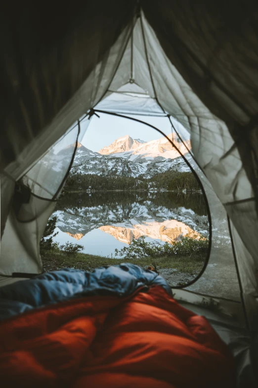 view of snowy mountains in the back from inside a tent