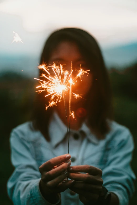 a girl holds a sparky sparkle stick in her hands