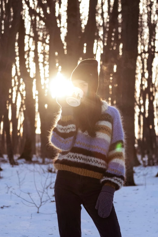 a person in the snow near trees and sunlight