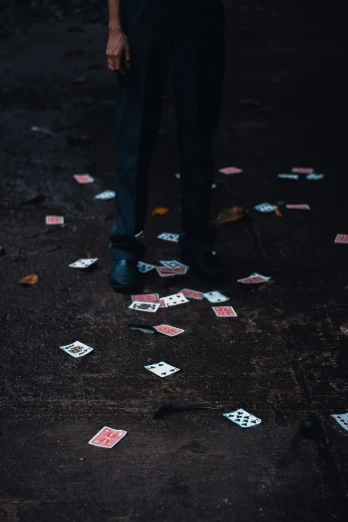 many playing cards scattered across the ground, leaving the path