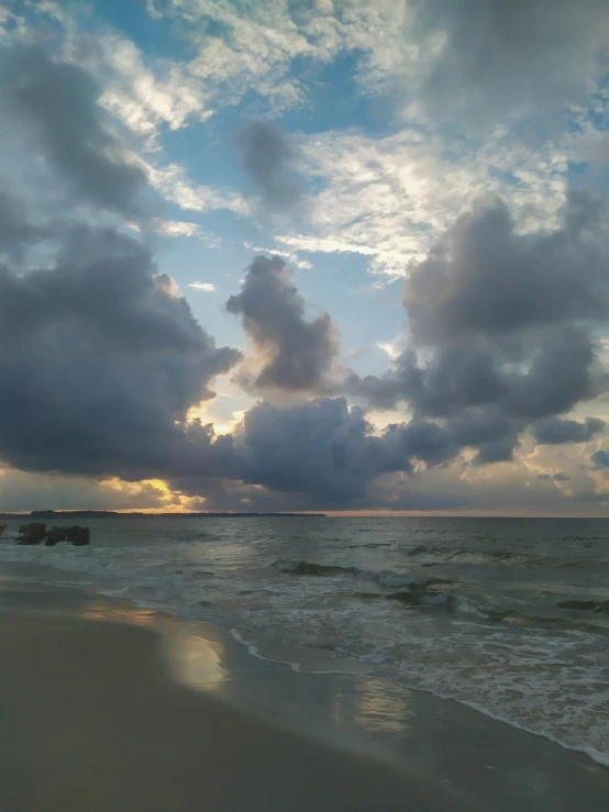 a view of some water and clouds at dusk