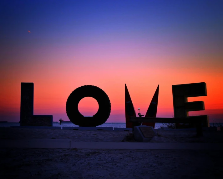 a statue that says love on a beach