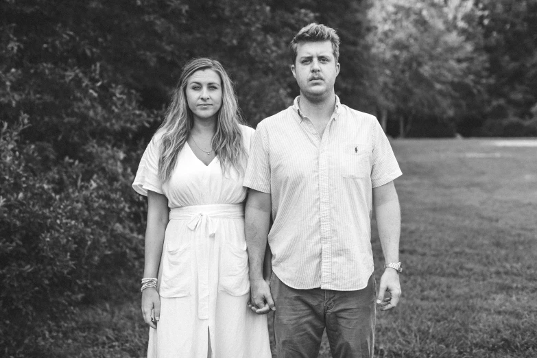 a man and a woman standing in the middle of a field