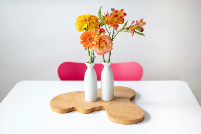 vases of orange and yellow flowers on a white table