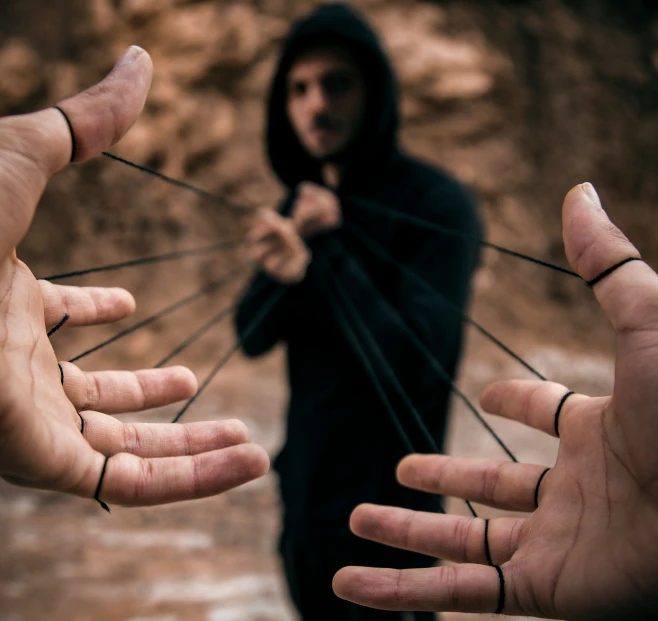 a man who is standing in the rain with three hands holding him out