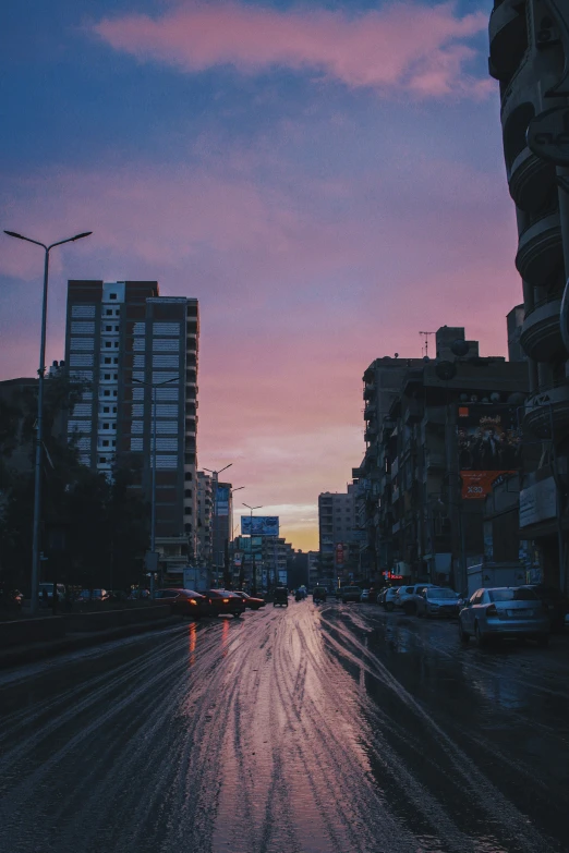 a city street lined with tall buildings at dusk