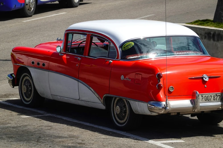 an orange and white car driving down the road