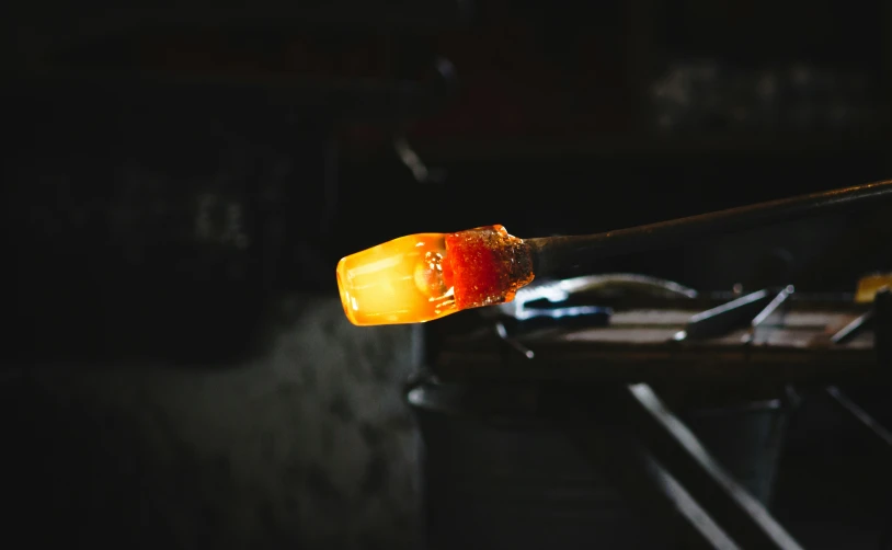 a bright orange object being held in the dark