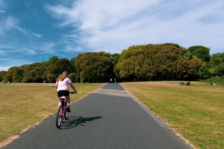 a woman is riding her bike down the road