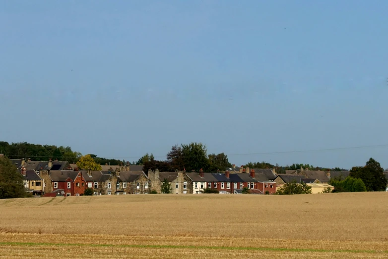the houses on a farm can be seen in front of the blue sky