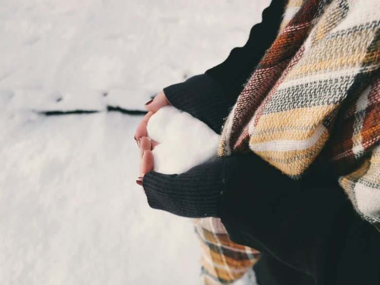 the snow is covering the sweaters while a woman holds out her hand