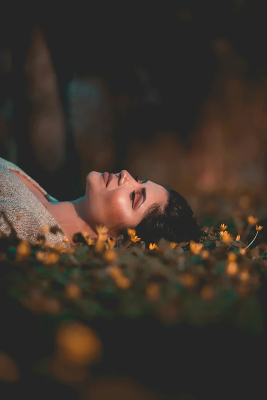 a woman laying on the ground with yellow flowers