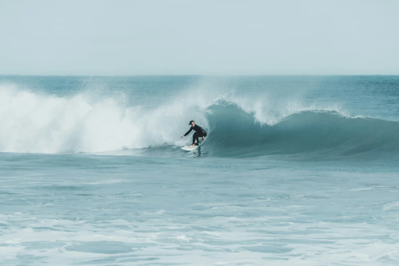 a man riding a surfboard on top of a wave in the ocean