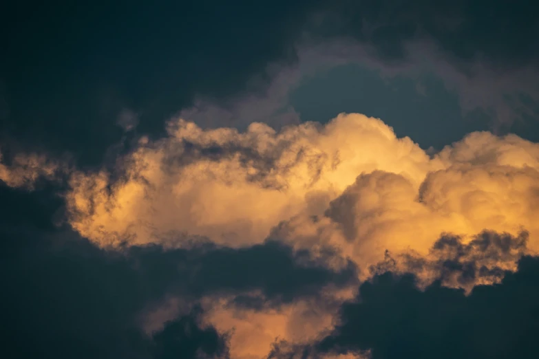 dark clouds with yellow lighting above the airplane