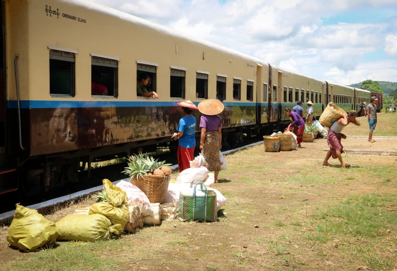 people getting on and off the train carrying sacks and baskets