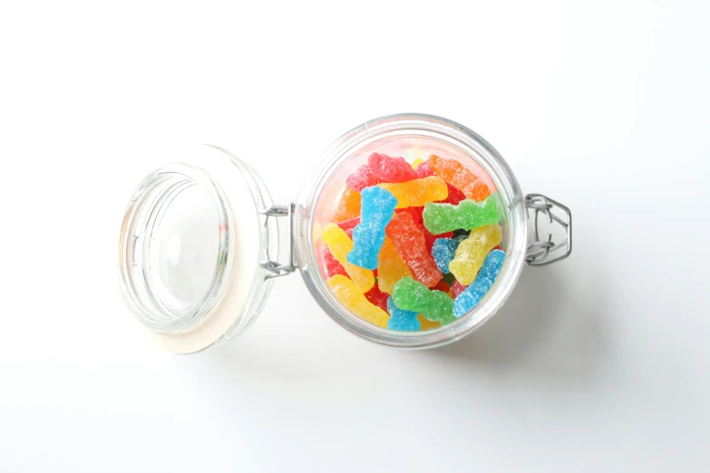 small glass jar with gummy bears inside of it