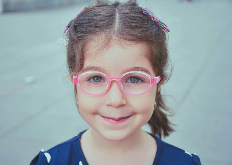 a  wearing pink glasses and smiling