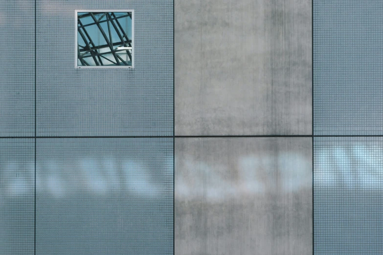 an abstract tiled wall and window with a sky reflected in it