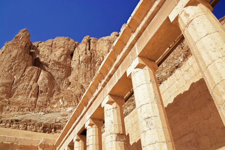 a row of stone pillars under a blue sky