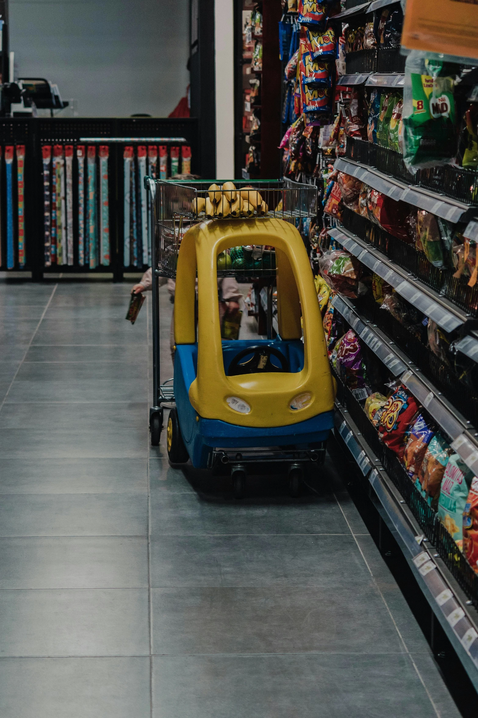 small  cart that's sitting on the floor in a grocery store