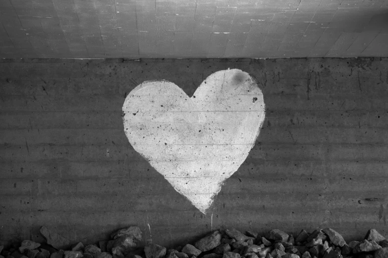 black and white pograph of heart drawn on cement