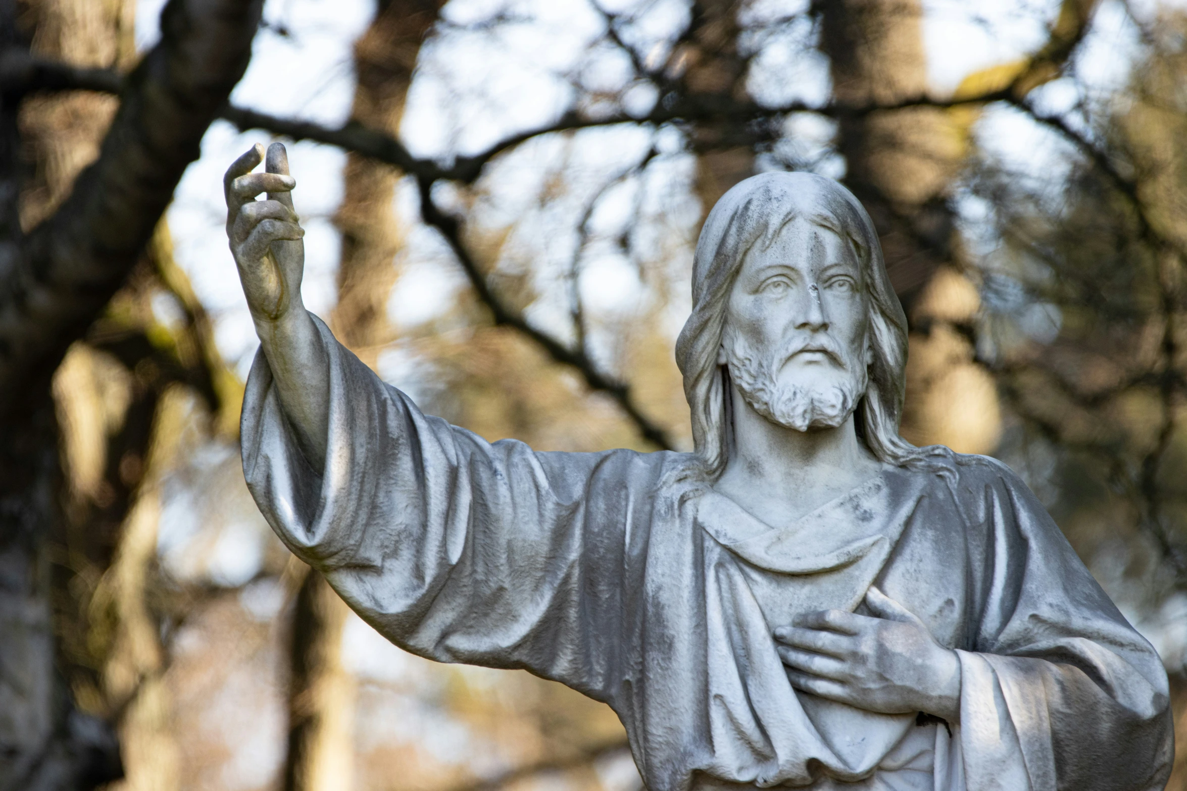 a statue of jesus in the middle of a park