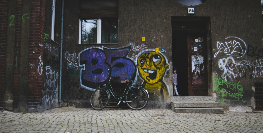 bike with graffiti and steps outside door in urban setting