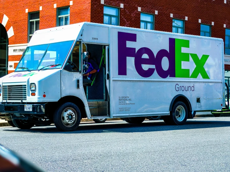 a fed ex truck parked outside a red brick building