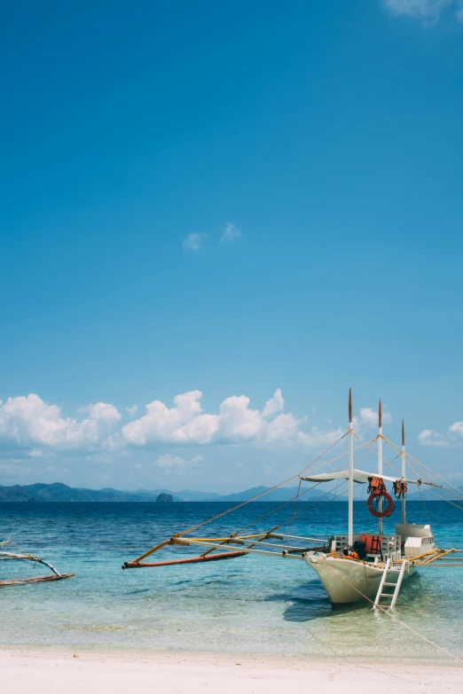 a white boat sits in shallow water near the shore