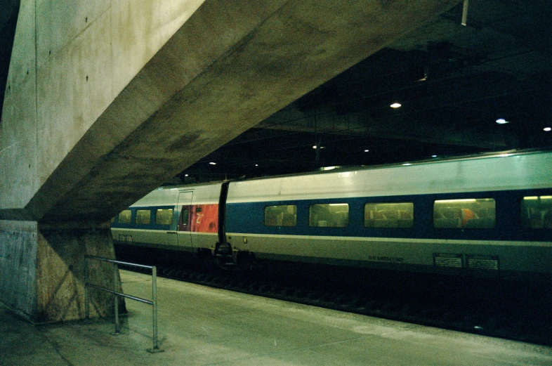 a train is passing by under a concrete structure