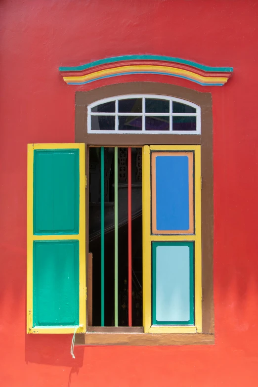 window with bars and shades on a red wall