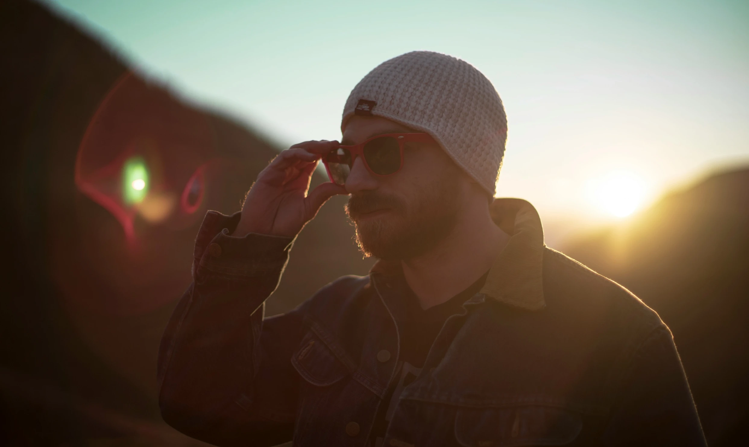 man in winter hat and sunglasses at sunrise