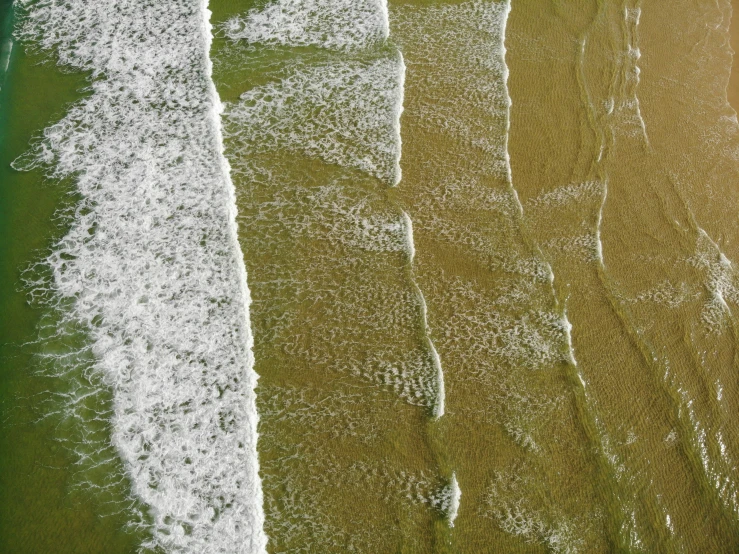 an overhead view of two beach waves and ocean waters