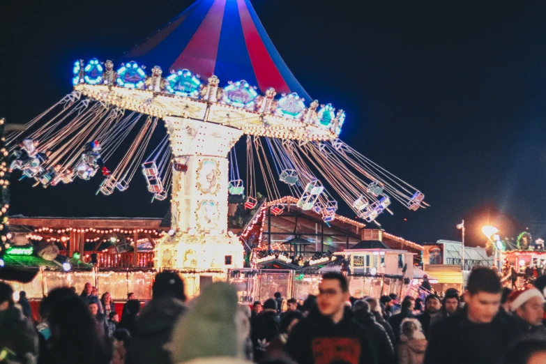 a crowd of people are walking around in a fair