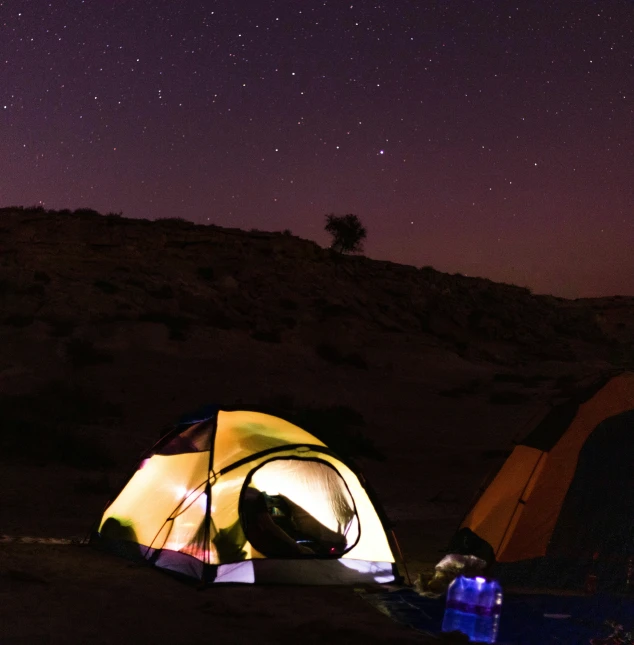 tents at night in the desert with stars above