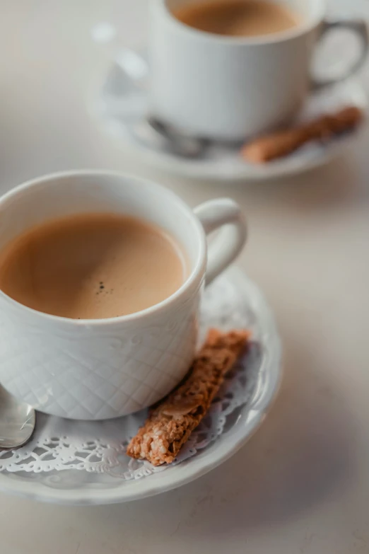 two cups with  chocolate sitting on them