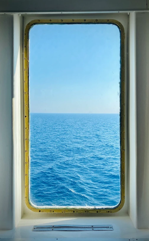 view out window of ocean through porthole of ship