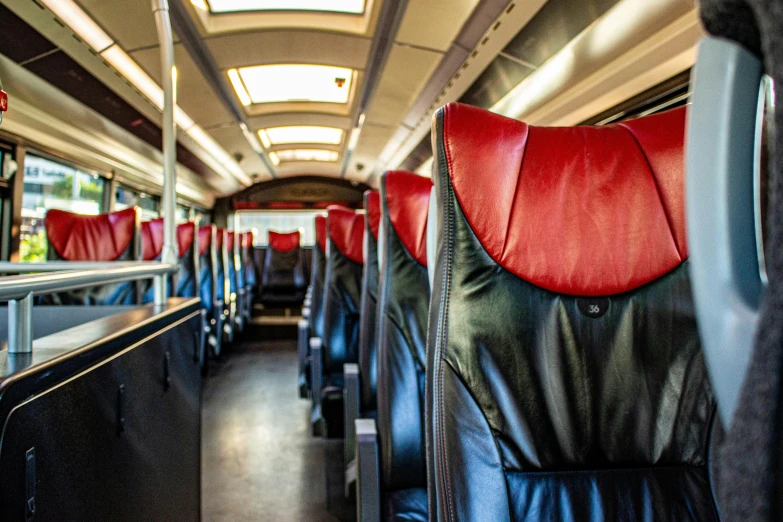 red leather seats are inside the rear seat of an empty bus