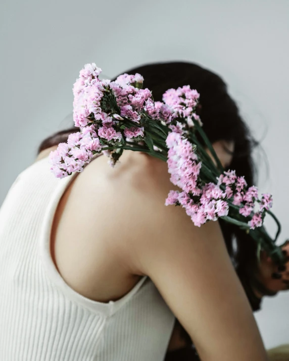 the woman holding the flowers is getting ready to blow on her face