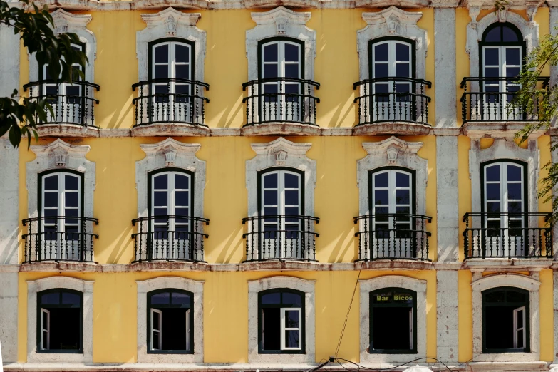 a building with multiple windows and black balconies