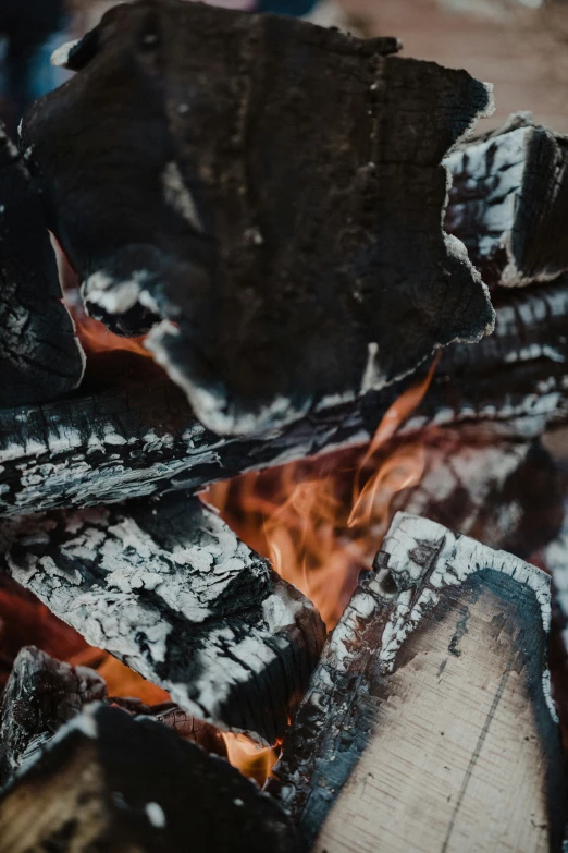 a camp stove with flame and rocks on the ground