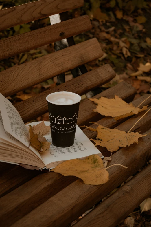 an open book on top of a table next to a cup of coffee