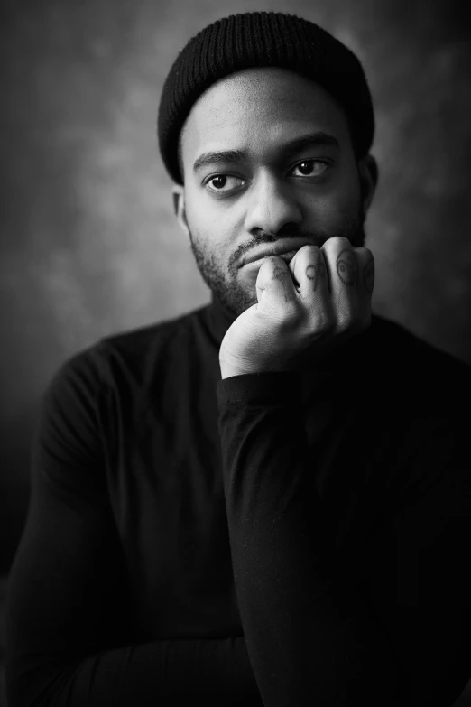 a black and white po of a person leaning against a chair