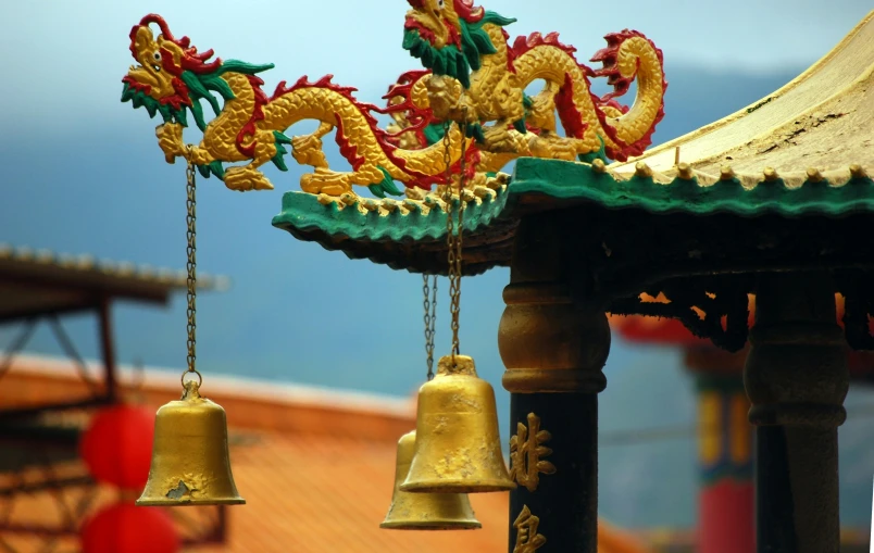 a bell and two small bells with gold dragon decorations on them